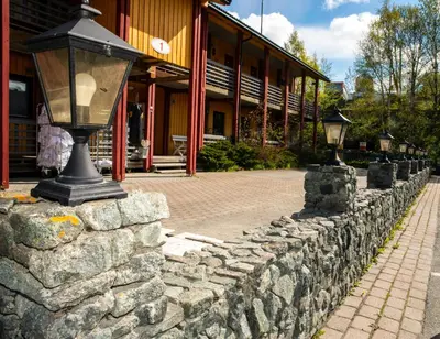 a stone wall with a street light in front of a building at Sandmoen Bed & Breakfast, Free Parking in Trondheim