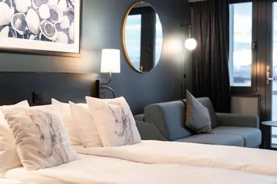a hotel room with a bed and a chair and a mirror at Scandic Alexandra Molde in Molde