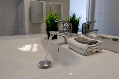 a bathroom sink with a faucet and a towel at Thon Hotel Måløy in Måløy