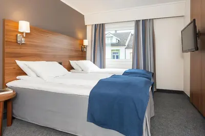 a hotel room with two beds and a window at Thon Hotel Backlund in Levanger