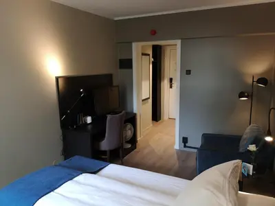 a hotel room with a bed and a living room at Thon Hotel Backlund in Levanger