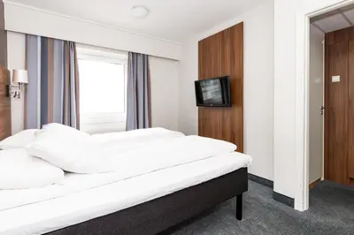 a hotel room with a bed and a television at Thon Hotel Backlund in Levanger