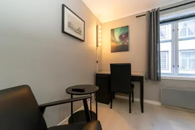 a living room with a desk and a chair at Pensjonat Jarlen in Trondheim