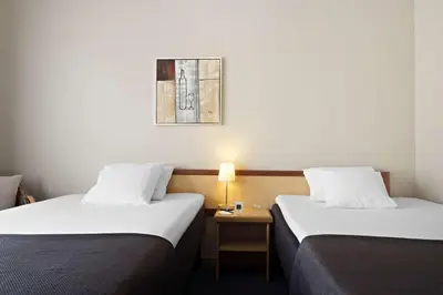a hotel room with two beds and a table with a lamp at Stav Hotel in Malvik
