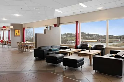 a waiting room with couches and tables and windows at Stav Hotel in Malvik
