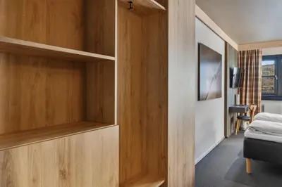 a bedroom with wooden shelves and a bed in a room at Trysil Hotel in Trysil