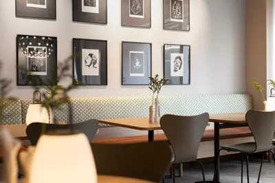 a restaurant with tables and chairs and pictures on the wall at Comfort Hotel Park in Trondheim
