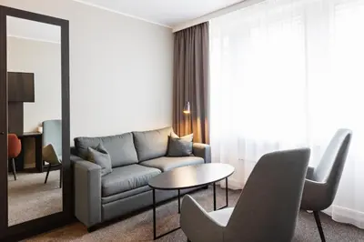 a living room with a couch and a table at Quality Hotel Augustin in Trondheim