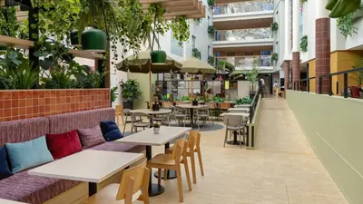 a restaurant with tables and chairs and plants at Comfort Hotel Trondheim in Trondheim