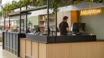 a man standing at the counter of a restaurant at Comfort Hotel Trondheim in Trondheim