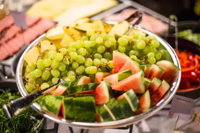 a plate of grapes and fruit on a table at Comfort Hotel Trondheim in Trondheim