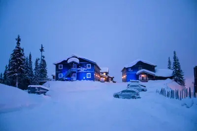 a blue house with a car parked in the snow at Kvitfjell Hotel Kvitfjellvegen 492 in Kvitfjell