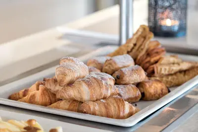 a tray of pastries and croissants in a bakery at Tyrifjord Hotell in Vikersund