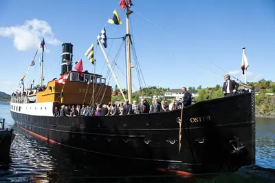 a group of people on a black boat in the water at Fjordslottet Hotel in Fotlandsvåg