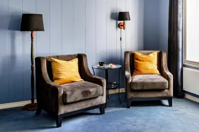 two chairs and a lamp in a room at Fjordslottet Hotel in Fotlandsvåg