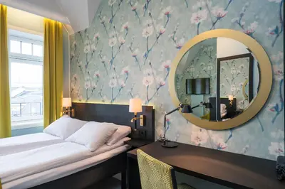 a bedroom with a bed and a mirror at Thon Hotel Nidaros in Trondheim