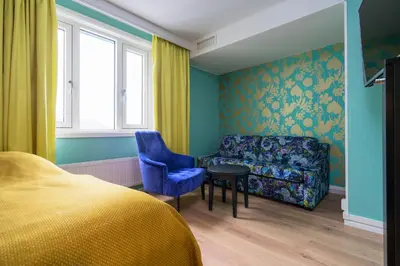 a bedroom with a bed and a chair and a couch at Thon Hotel Nidaros in Trondheim