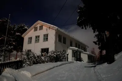 a white house with snow in front of it at Furulund Pensjonat in Ron