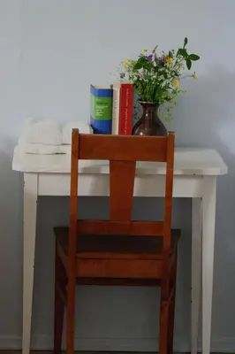 a table with a vase of flowers and books at Furulund Pensjonat in Ron