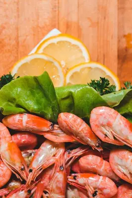 a pile of shrimp and vegetables next to oranges at Håholmen - by Classic Norway Hotels in Karvåg