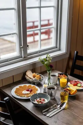 a table with plates of food on top of it at Håholmen - by Classic Norway Hotels in Karvåg