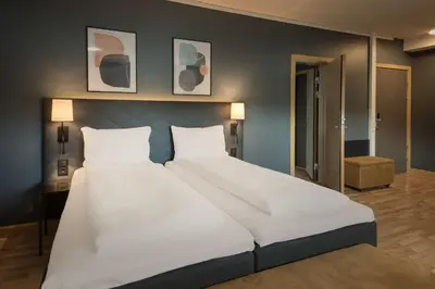 a large white bed in a bedroom with two pillows at Scandic Solsiden in Trondheim