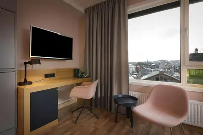 a hotel room with a desk and a window at Scandic Solsiden in Trondheim