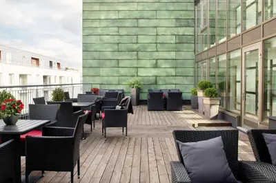 a patio with tables and chairs on a building at Scandic Solsiden in Trondheim