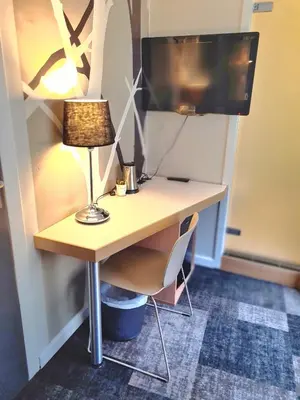 a desk with a lamp and a computer monitor on it at City Living Sentrum Hotel in Trondheim