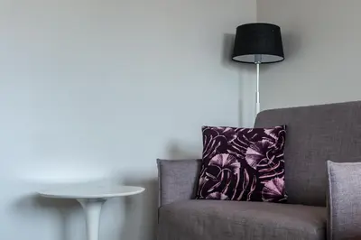 a chair with a purple pillow next to a table at City Living Sentrum Hotel in Trondheim