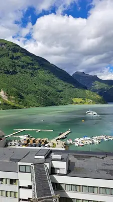 a view of a body of water with boats at Havila Hotel Geiranger in Geiranger