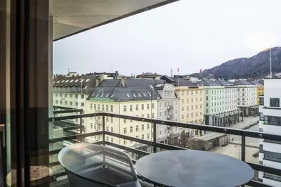 a view of a city from a balcony with a table and chairs at Hotel Norge by Scandic in Bergen