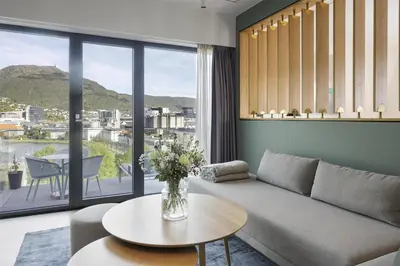 a living room with a couch and a table at Hotel Norge by Scandic in Bergen