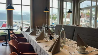 a long table in a restaurant with bottles and chairs at Ryfylke Fjordhotel in Sand