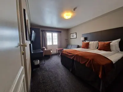 a hotel room with a large bed and a window at Dr. Holms Hotel in Geilo