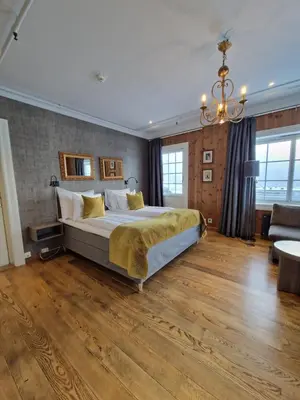 a bedroom with a large bed and a chandelier at Dr. Holms Hotel in Geilo