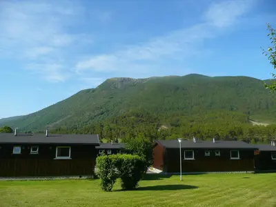 a house with a mountain in the background at Dovre Motell in Dovre