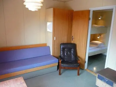 a room with a blue bench and a chair and a bed at Dovre Motell in Dovre