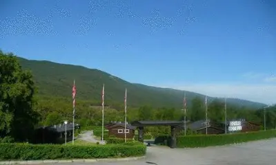 a building with a mountain in the background with flags at Dovre Motell in Dovre