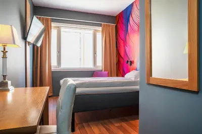 a small bedroom with a bed and a window at Thon Hotel Storgata in Kristiansund