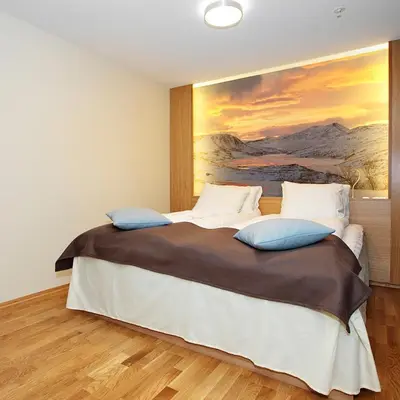 a bedroom with a large bed with a painting on the wall at Frich`s Hotel Surnadal in Surnadal