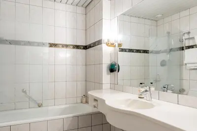 a white bathroom with a sink and a tub at Fleischer's Hotel in Vossevangen