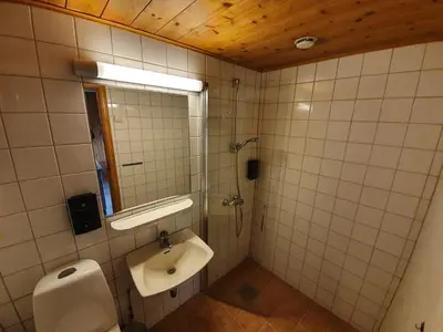 a bathroom with a sink and a shower with a mirror at Vertshuset Røros in Røros