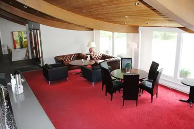 a living room with a couch and a table and chairs at Støren Hotel in Storen