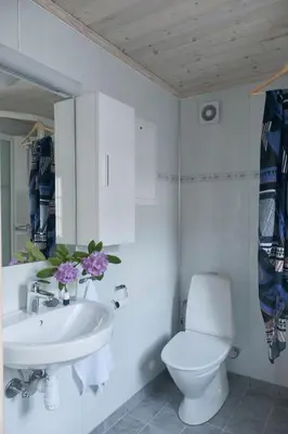 a white bathroom with a toilet and a sink at Vangsgaarden Gjestgiveri in Aurland