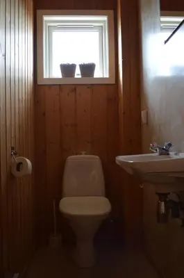 a bathroom with a toilet and a sink and a window at Nordseter Fjellpark, Hyttegrend in Nordseter