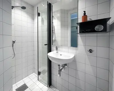 a white bathroom with a sink and a shower at Trolltunga Hotel in Odda