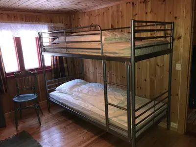 a bunk bed room with two bunk beds and a chair at Løngdal in Tuddal