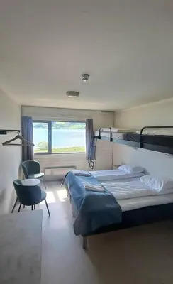 a bedroom with two bunk beds and a chair at Voss Vandrarheim Hostel in Vossevangen