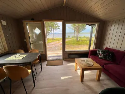 a living room with a red couch and a table at Femundtunet in Drevsjø